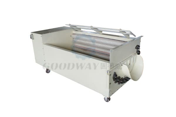 GOODWAY cassava washing and peeling unit with exposed brush rollers, spray piping and wheeled frame. Reference equipment photograph.