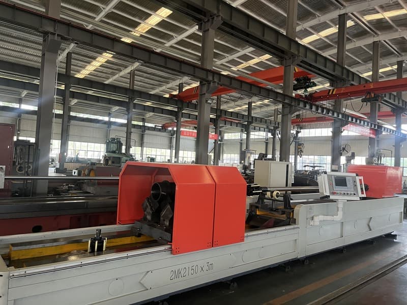 Long horizontal cylinder honing machine photographed in a factory, with supported workpiece and driven head. Reference equipment photograph.