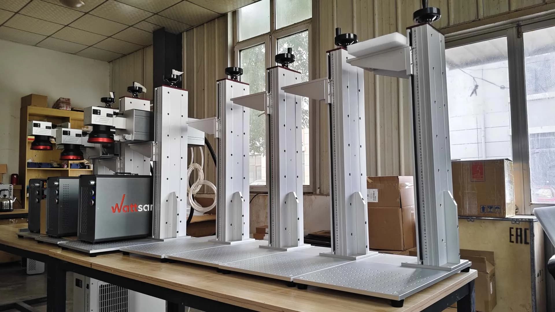 Wattsan fiber laser markers at a factory workstation. Reference equipment photograph.