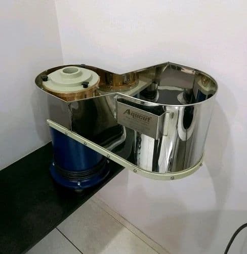 AQUCUT banana slicer with a stainless cutting enclosure, feed guide and adjacent drive motor. Reference equipment photograph.