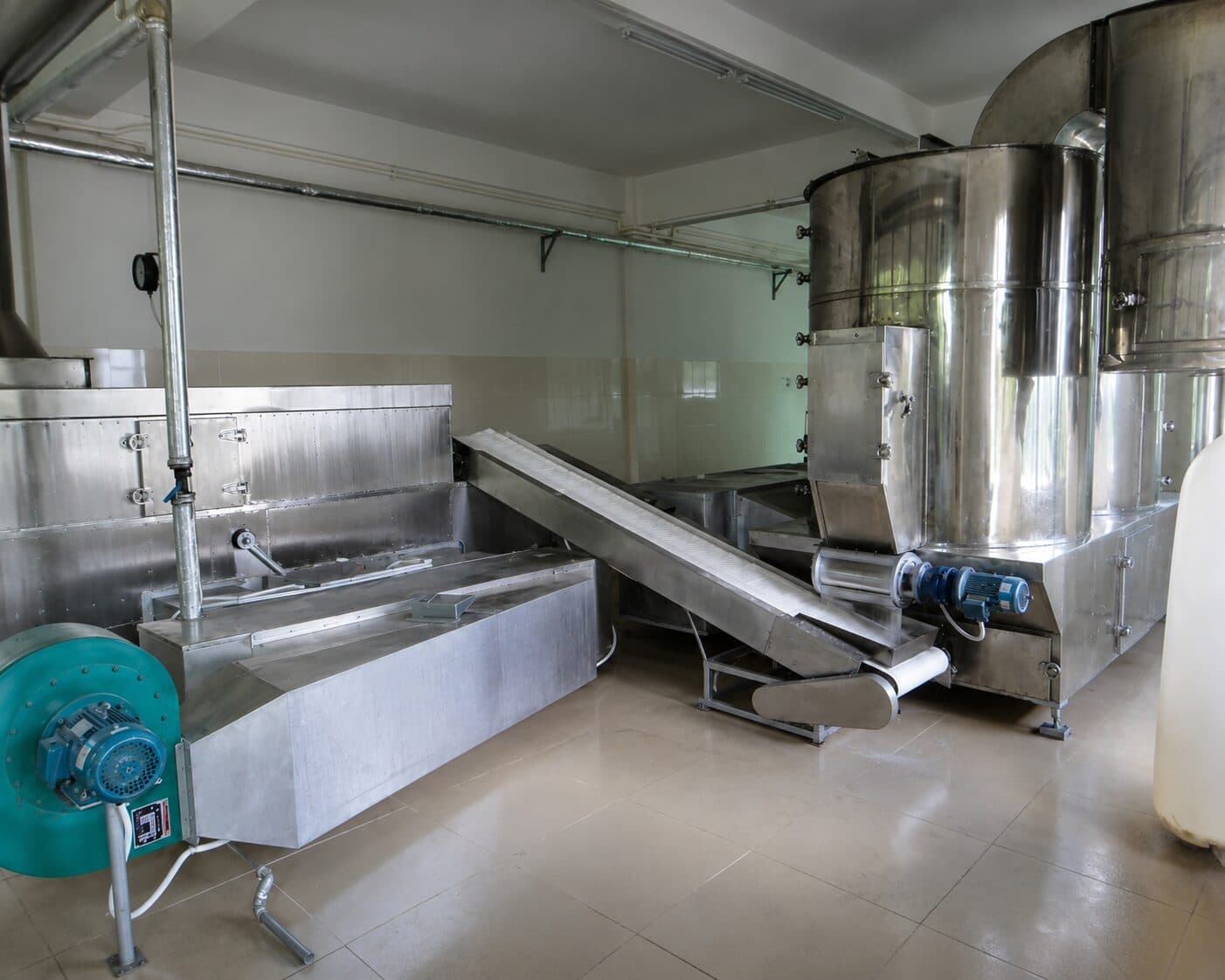 Desiccated coconut drying installation with stainless drying vessels, connecting conveyor and air-handling equipment. Reference equipment photograph.