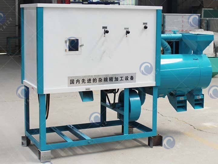 White and teal maize milling unit photographed in a workshop, with enclosed milling section, motor drive and product outlet; original watermark retained. Reference equipment photograph.
