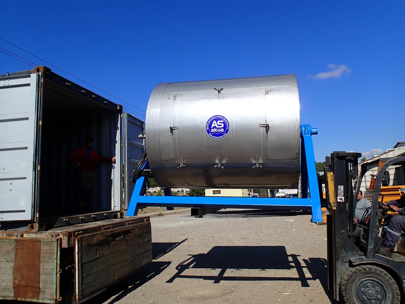 ASAKUA shore-based aquaculture net drum washer photographed in a loading area. Reference equipment photograph.