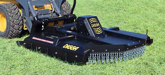 Digga skid-steer brush cutting deck fitted to a carrier on a grassy work area. Reference equipment photograph.