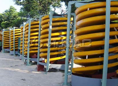Rows of yellow spiral separation chutes in steel support frames, photographed outdoors. Reference equipment photograph.