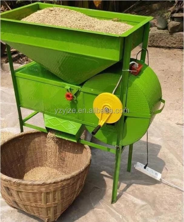Green grain winnower with a hopper and side blower photographed in use. Reference equipment photograph.