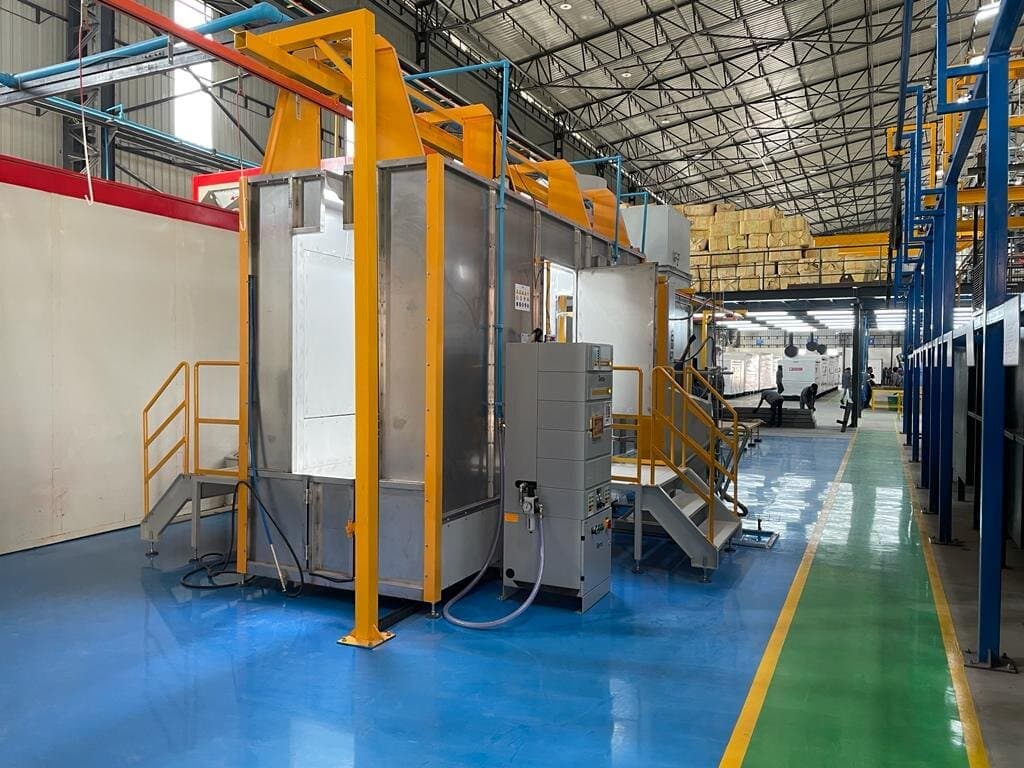 OptiFinish powder booth installation in a factory with handling and ductwork. Reference equipment photograph.