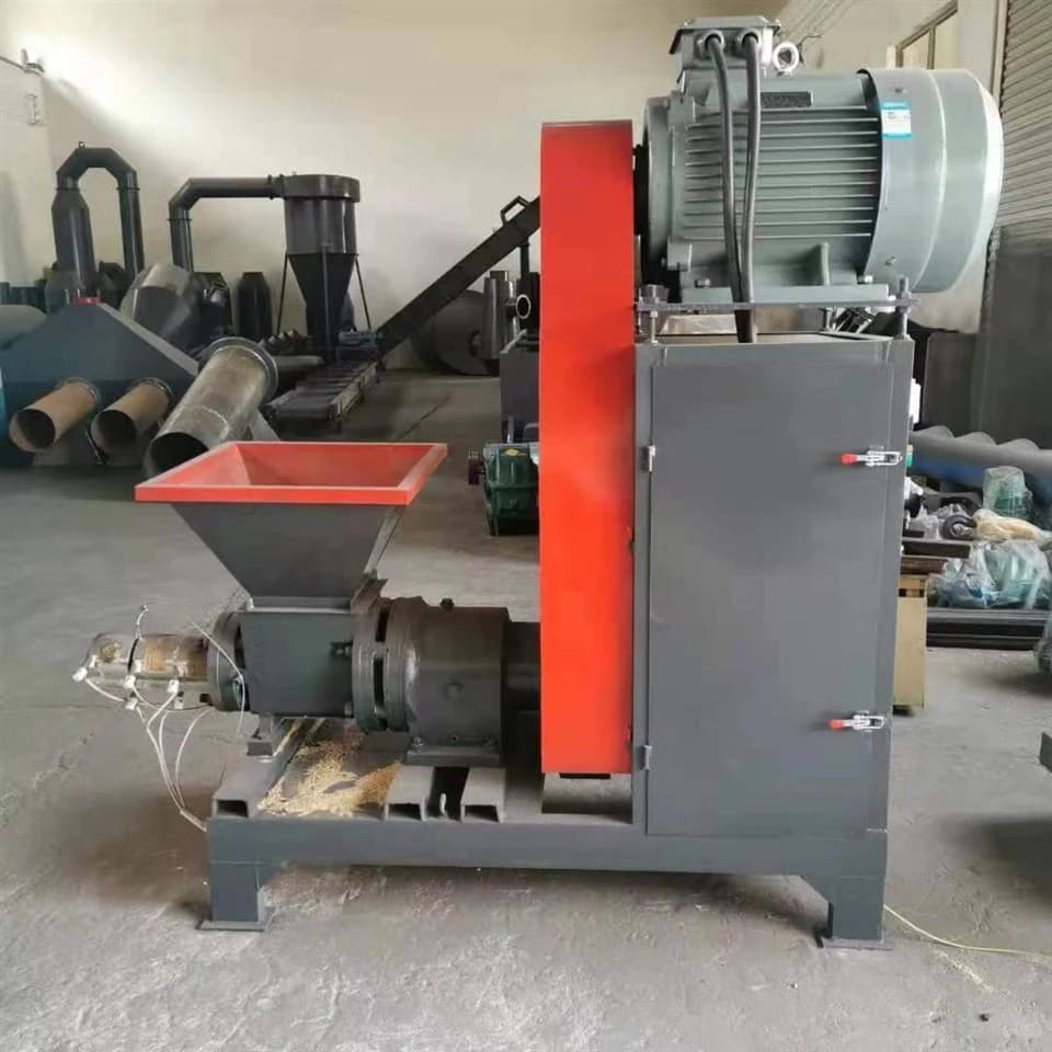 Mikim wood briquette press photographed in a workshop with its feed hopper, drive and press outlet. Reference equipment photograph.