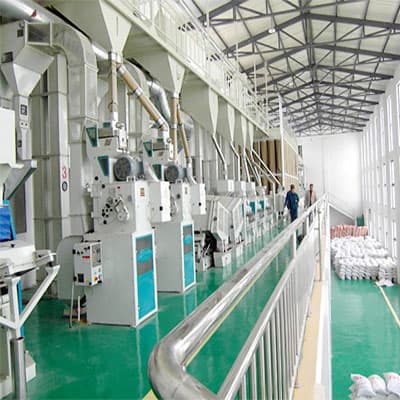 Installed white and green grain processing machines connected in a factory line. Reference equipment photograph.