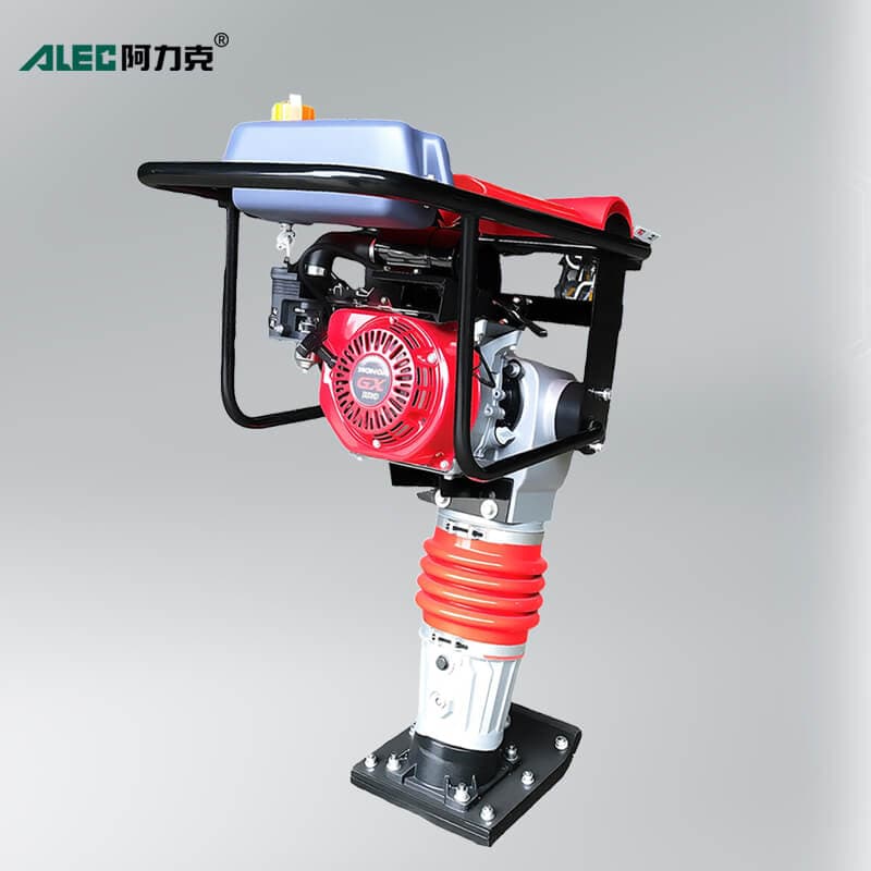 Red gasoline rammer with a compact engine, bellows and compaction foot. Reference equipment photograph.
