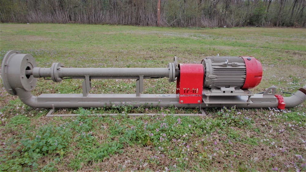 Portable trash-water suction pump with a long shaft, submerged pump head, motor and support frame, photographed outdoors. Reference equipment photograph.