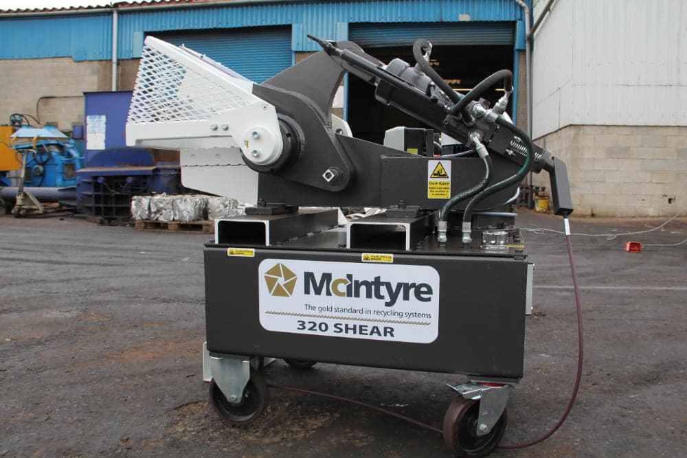 McIntyre 320 alligator shear photographed outdoors with its hinged blade guard and hydraulic cutting assembly. Reference equipment photograph.