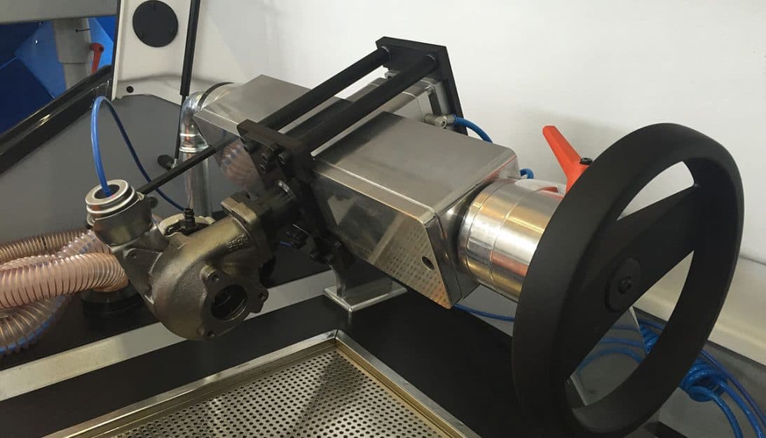 Balancing fixture with rotor supports and a driven shaft in a machine enclosure. Reference equipment photograph.