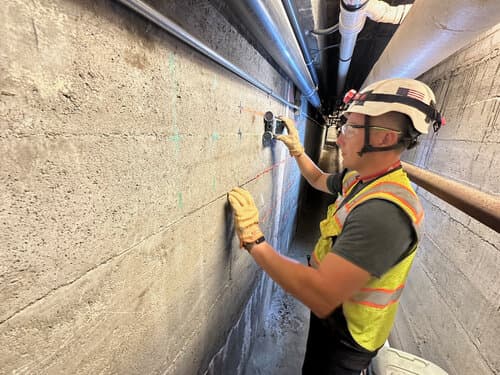 Profometer PM8000 cover-meter sensor being used to scan a concrete wall. Reference equipment photograph.