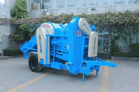 Blue trailer-mounted paddy thresher photographed outdoors on a paved yard. Reference equipment photograph.