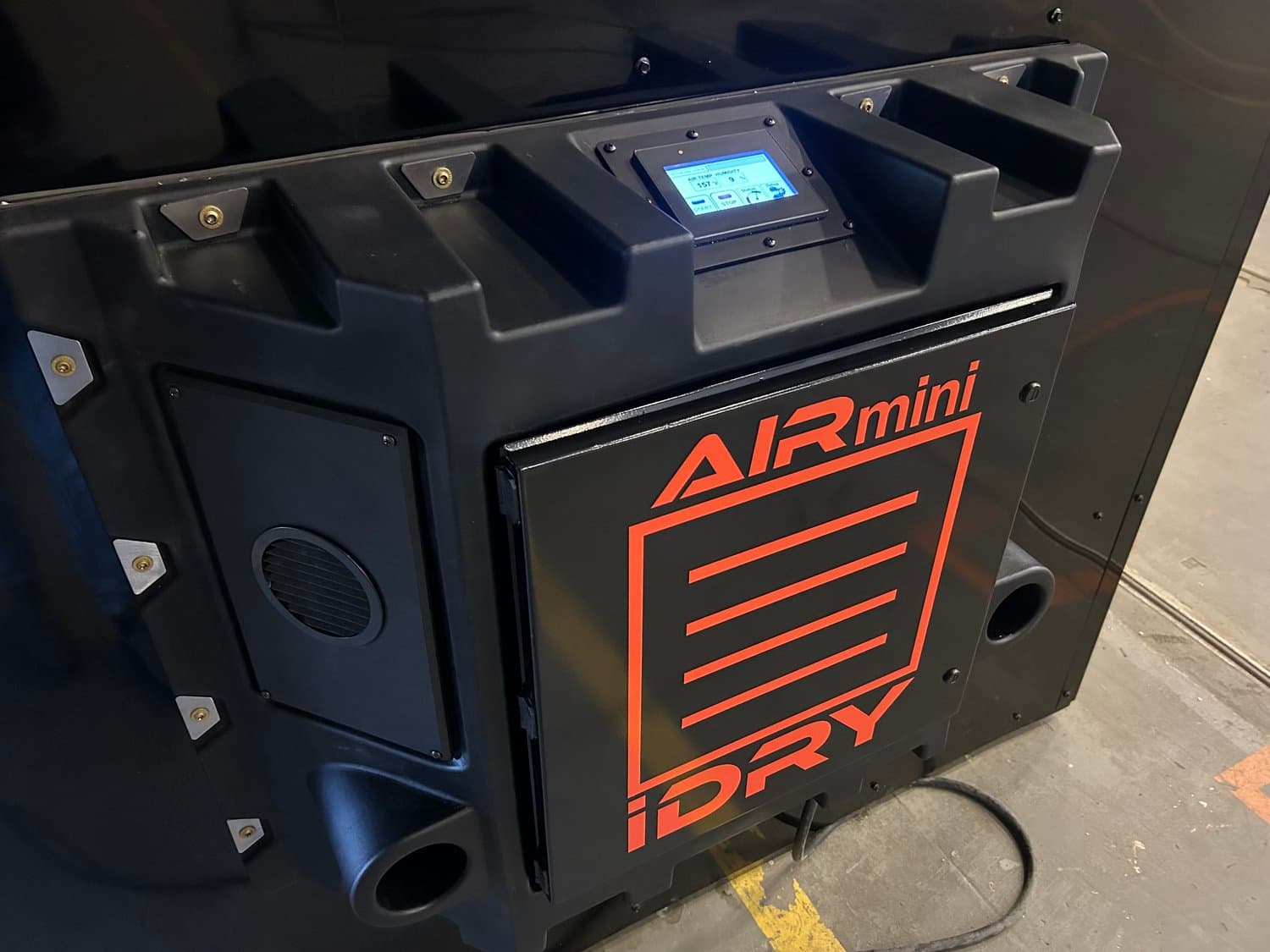 iDRY AIRmini drying module photographed with its fan outlets and temperature/humidity control panel. Reference equipment photograph.
