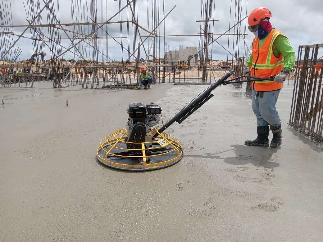 Walk-behind power trowel operated on a fresh concrete slab. Reference equipment photograph.