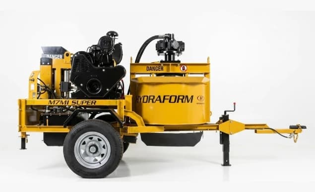 Hydraform M7M1 soil-cement press with integrated mixer and trailer. Reference equipment photograph.