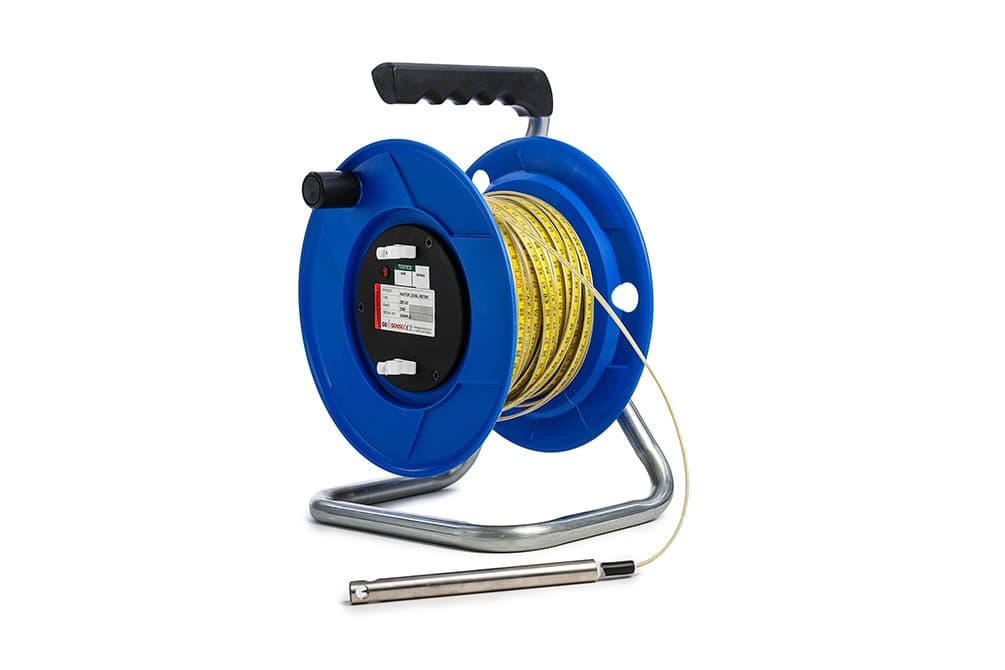Blue graduated-tape reel with a stainless water-contact probe. Reference equipment photograph.