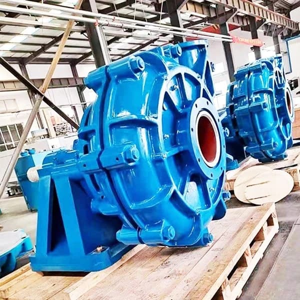 Blue slurry booster pumps on wooden pallets photographed inside a factory. Reference equipment photograph.