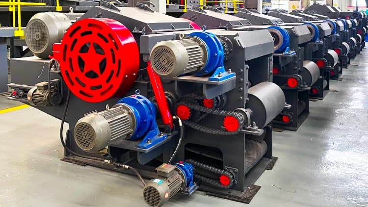 Kowloon drum wood chippers photographed in a workshop with guarded drives and feed openings. Reference equipment photograph.