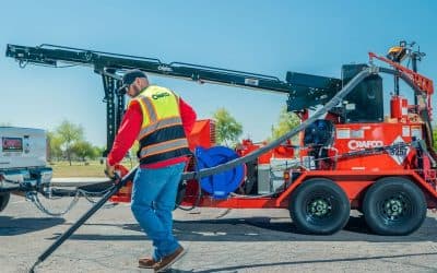 Crafco crack-sealing melter in use with an application hose on a paved surface. Reference equipment photograph.