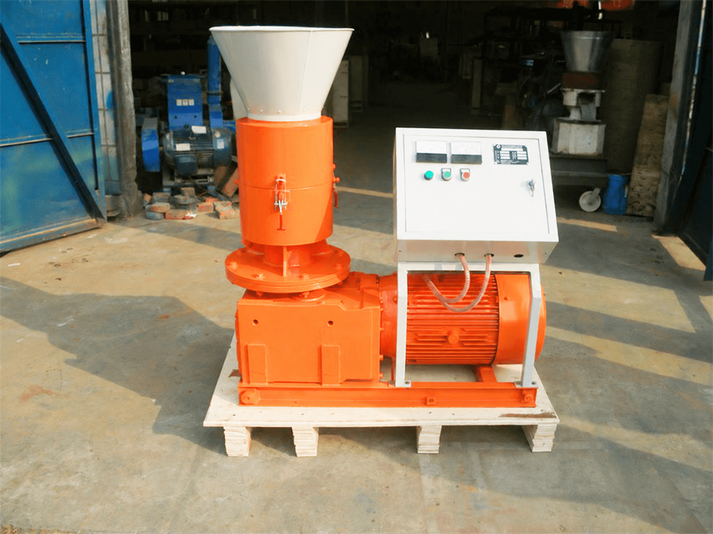 Feed pellet mill with hopper, press body, motor, frame and control cabinet; the overlaid telephone number was locally removed. Reference equipment photograph.