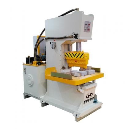 SMT hydraulic splitting machine with opposed tooling and concrete blocks. Reference equipment photograph.