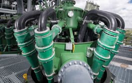 Green hydrocyclone cluster with feed pipes and lower cone sections in an installed plant. Reference equipment photograph.