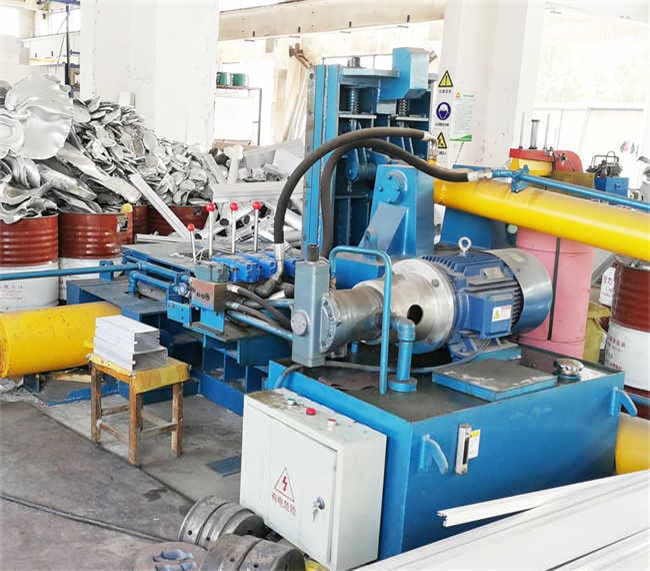 Diloya Y81-63 compact scrap-metal baler photographed in a workshop with its pressing chamber and hydraulic drive. Reference equipment photograph.